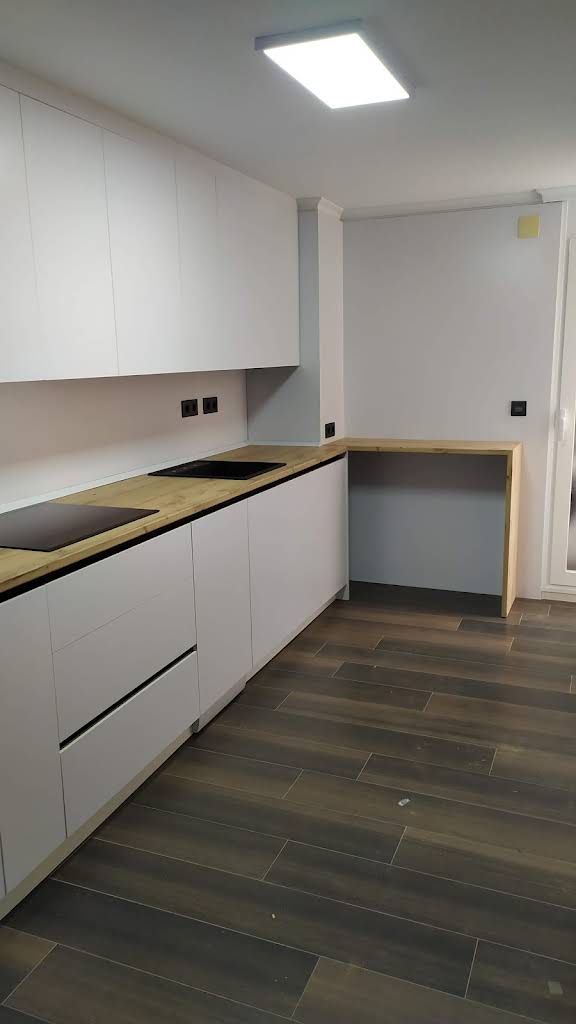 Cocina blanca a medida con isla y encimera de madera